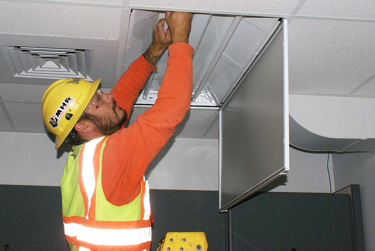 Electrician installing lighting in a commercial building